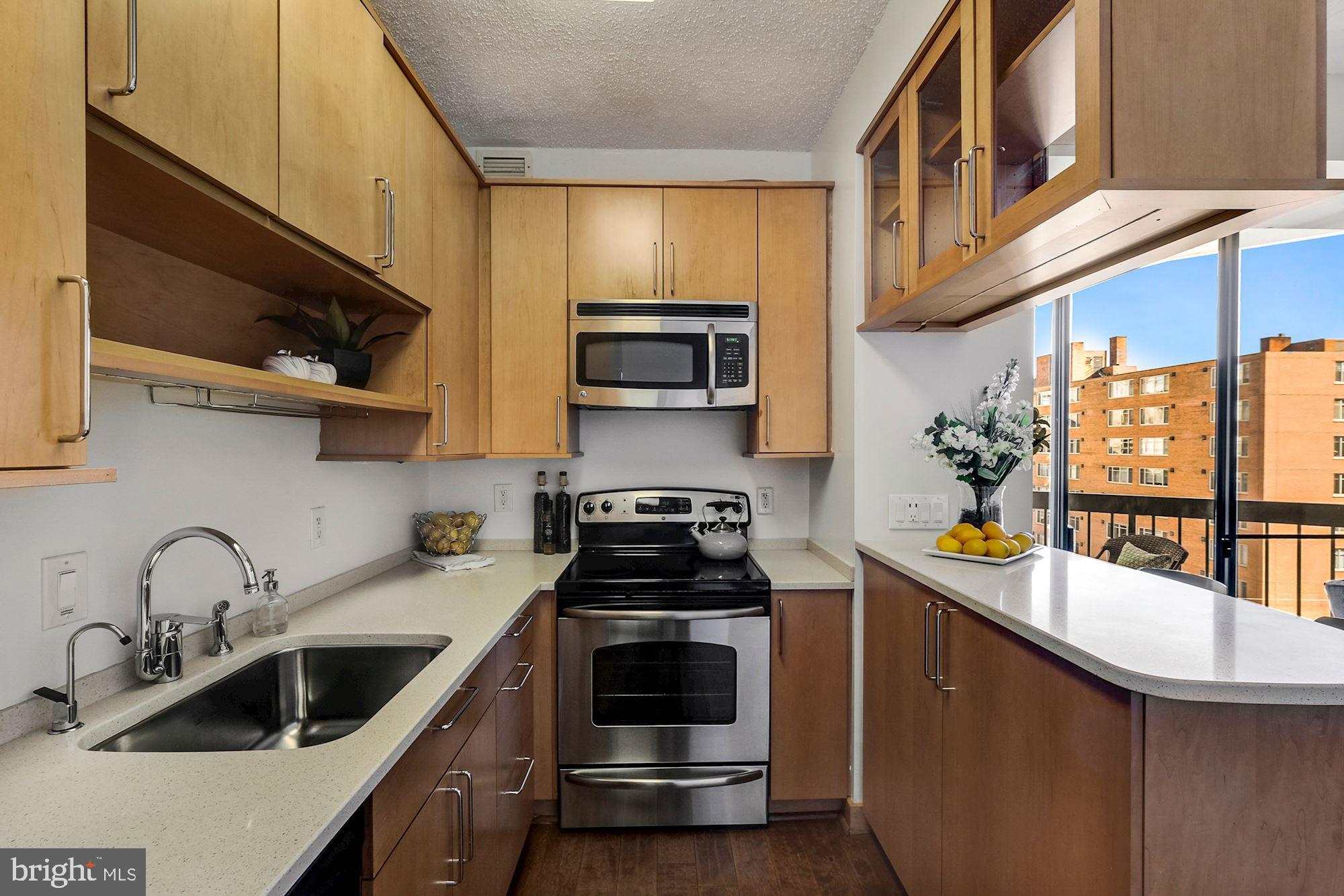 955 26th Street Northwest, Unit 707 Washington, DC 20037 - Photo 9 of 20 a kitchen with stainless steel appliances a stove sink microwave and cabinets