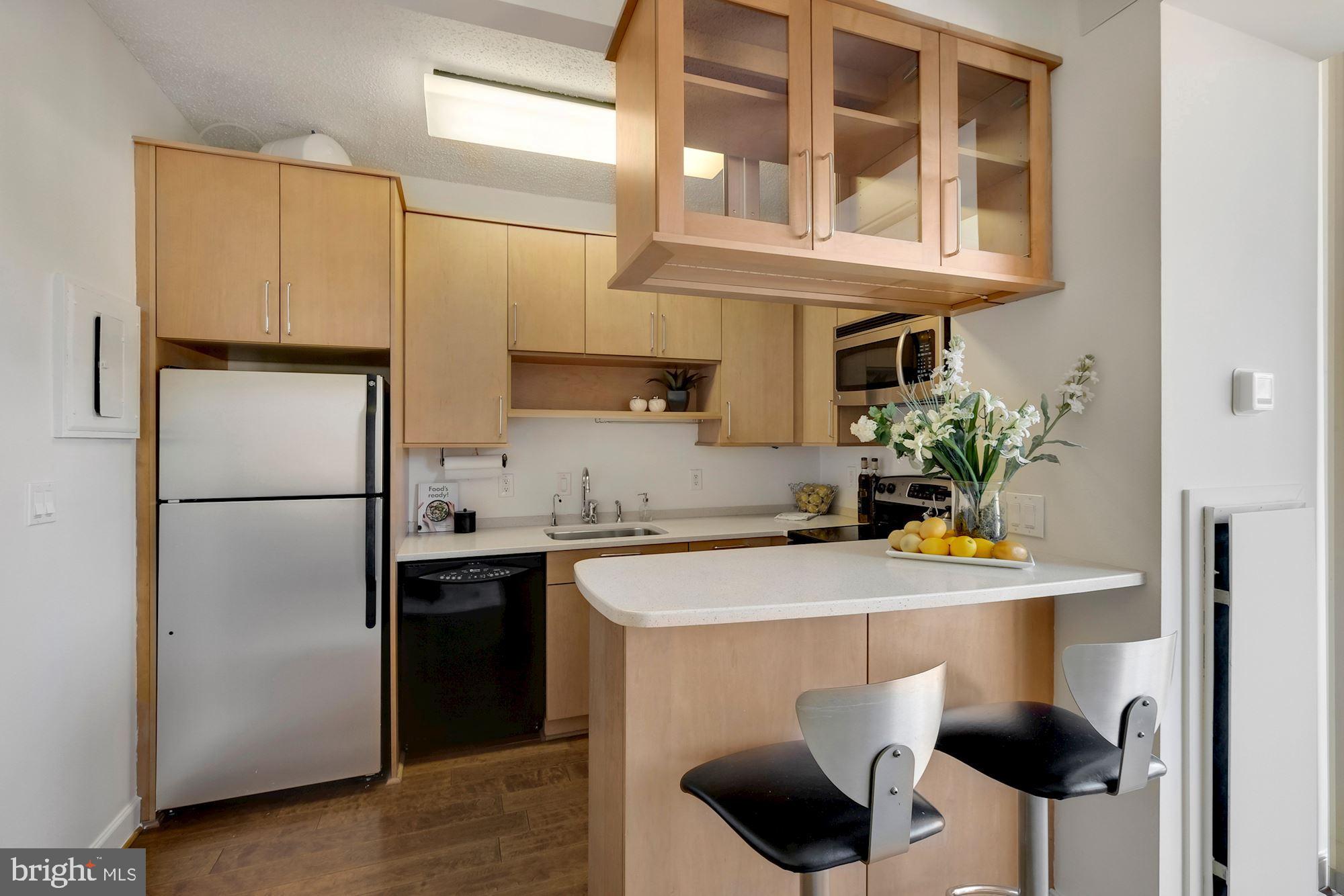 955 26th Street Northwest, Unit 707 Washington, DC 20037 - Photo 10 of 20 a kitchen with stainless steel appliances a sink and a refrigerator
