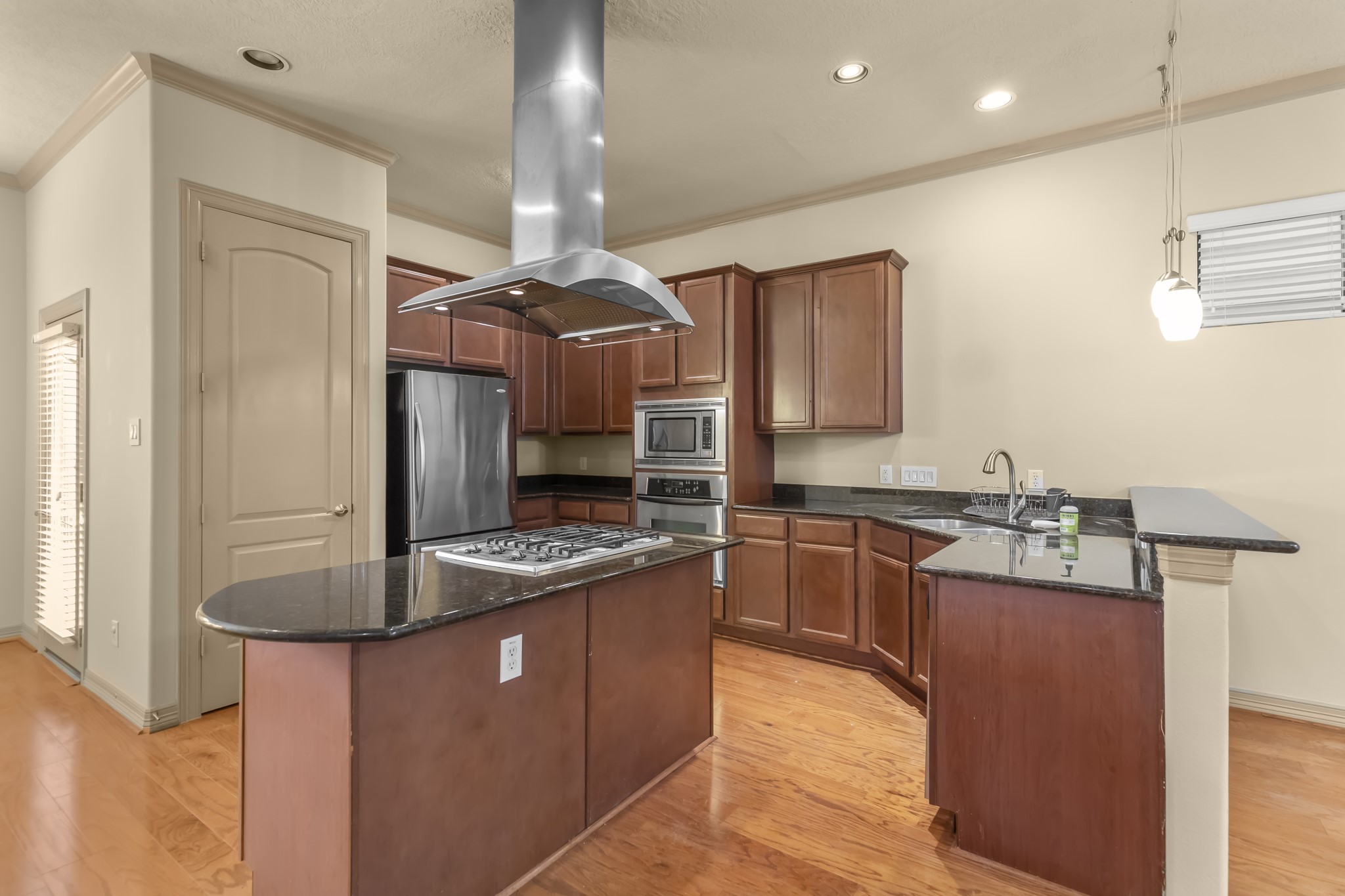 1607 Bass Street, Unit B Houston, TX 77007 - Photo 12 of 39 a kitchen with kitchen island granite countertop a sink stainless steel appliances and cabinets