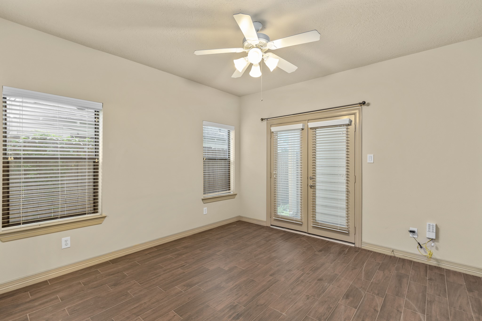 1607 Bass Street, Unit B Houston, TX 77007 - Photo 7 of 39 an empty room with wooden floor chandelier fan and windows