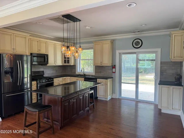 a kitchen with granite countertop a stove refrigerator and microwave