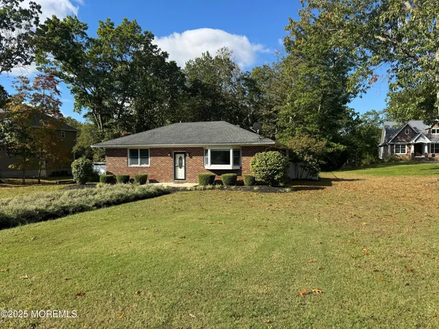a front view of a house with yard and green space