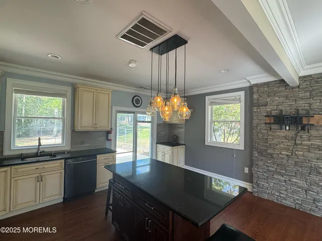 a kitchen with granite countertop a sink cabinets and window