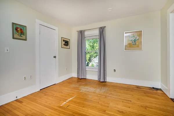 a view of a room with wooden floor and window