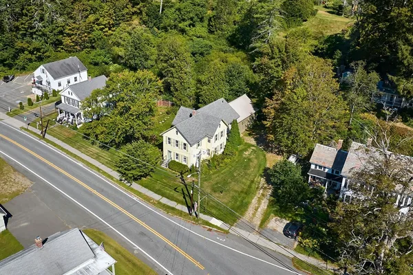 an aerial view of residential houses with outdoor space and trees