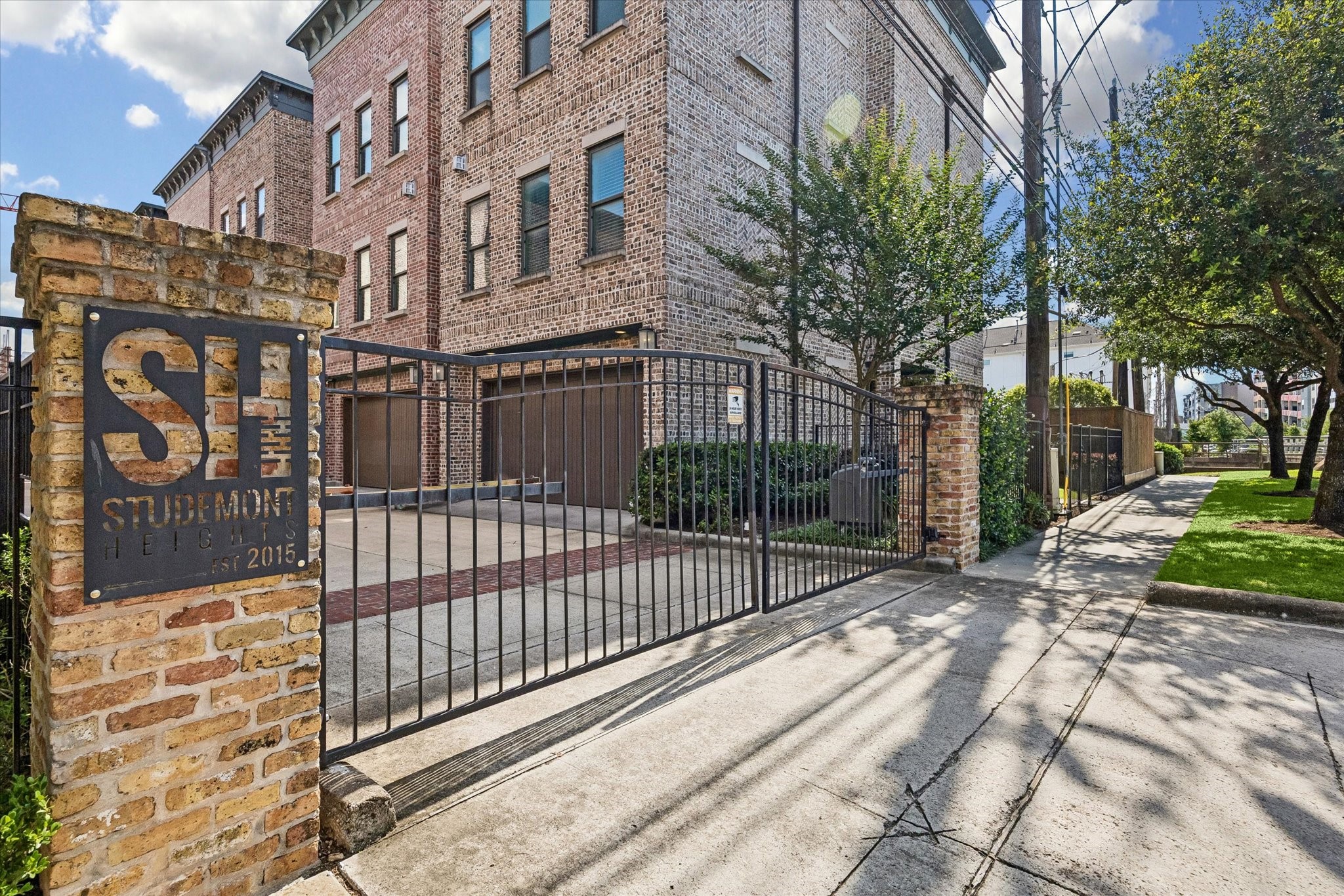 2913 Hicks Street Houston, TX 77007 - Photo 28 of 28 The gated entrance to Studemont Heights creates an inviting sense of privacy and exclusivity, framed by timeless brick detailing and mature landscaping.