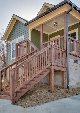a view of a house with wooden deck front of house