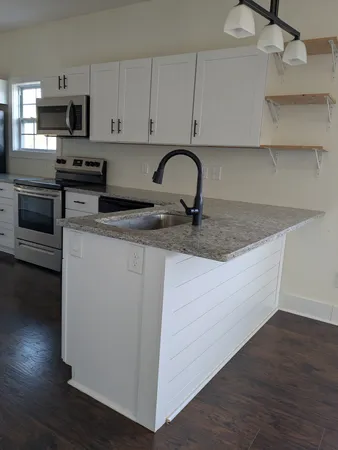a kitchen with stainless steel appliances granite countertop a sink a stove and a microwave