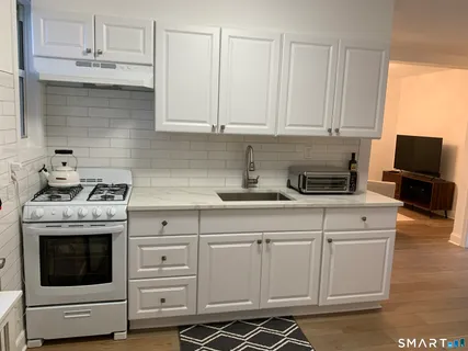a kitchen with white cabinets and white appliances