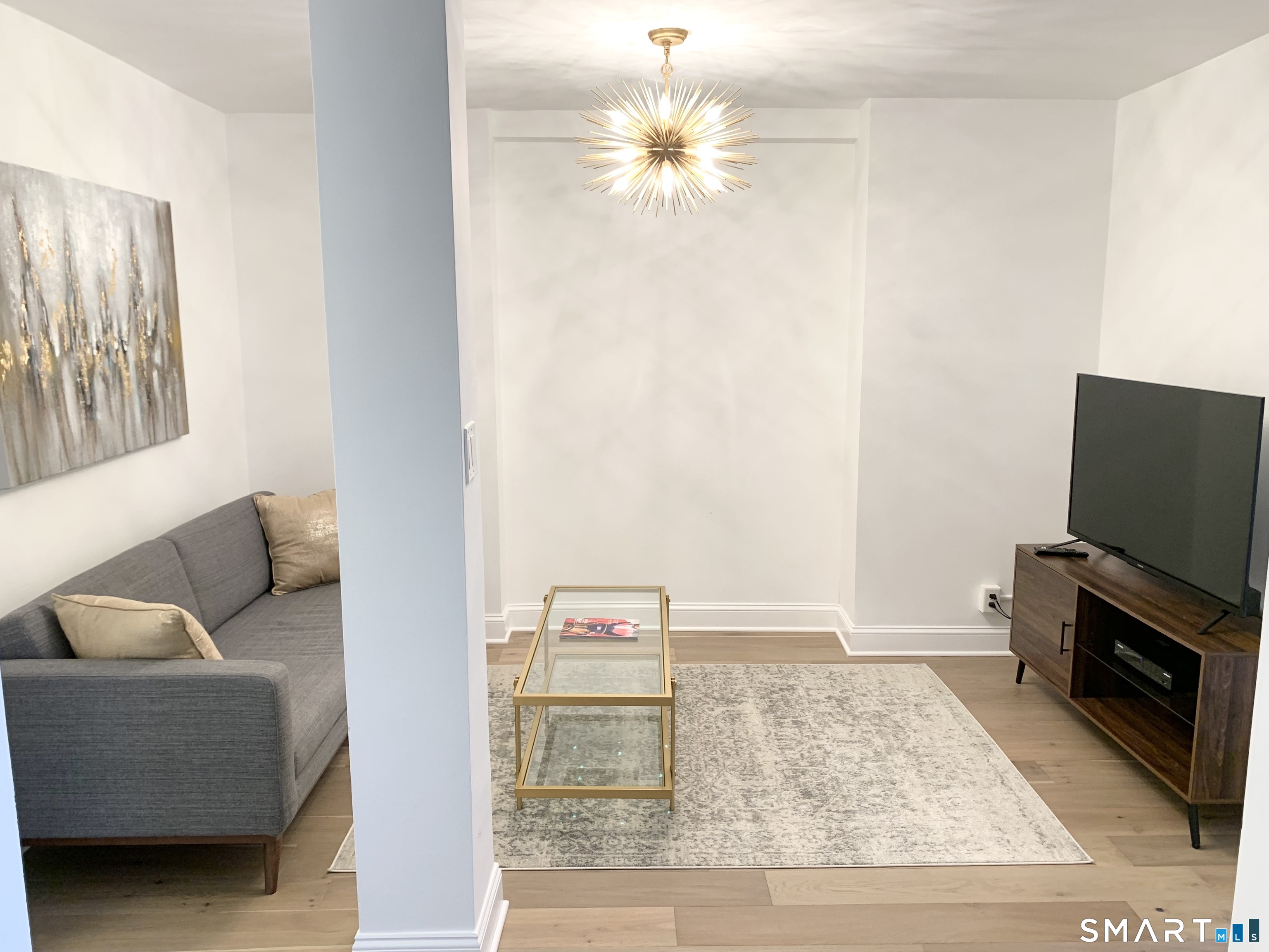 700 Summer Street, Unit 1M Stamford, CT 06901 - Photo 2 of 22 a living room with furniture and a flat screen tv