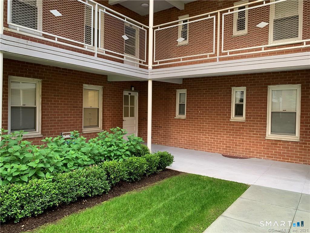 700 Summer Street, Unit 1M Stamford, CT 06901 - Photo 21 of 22 a view of a house with a yard and plants