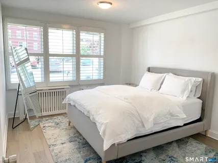 a large bed sitting in a bedroom next to a window