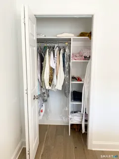a view of walk in closet with clothes and shoes