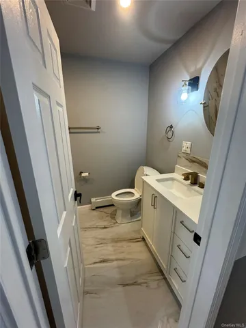 a bathroom with a sink a toilet and a mirror