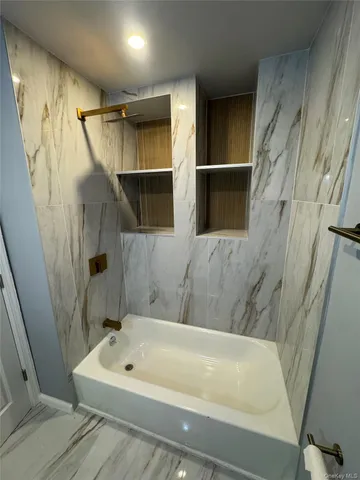 a bathroom with a bathtub and shower