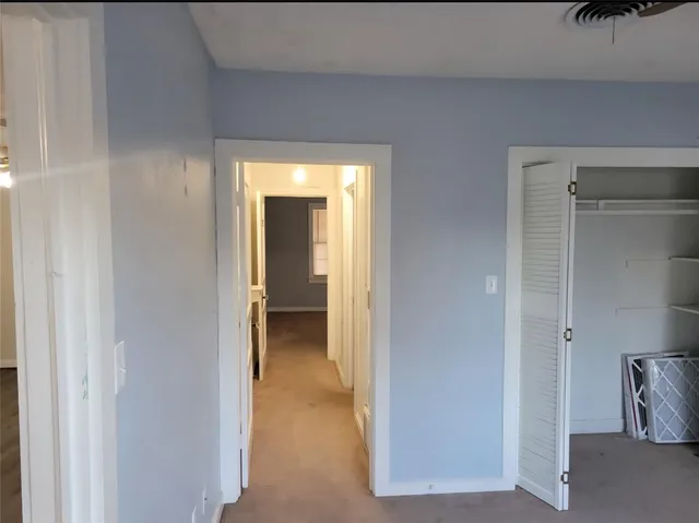 a view of a hallway with closet and a couch