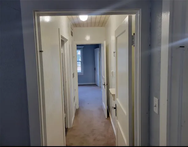 a view of a hallway with wooden shelves