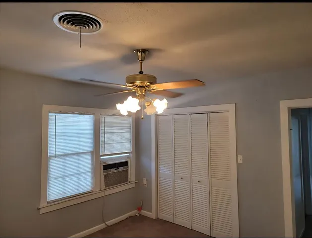 a view of a livingroom with a chandelier fan and kitchen view