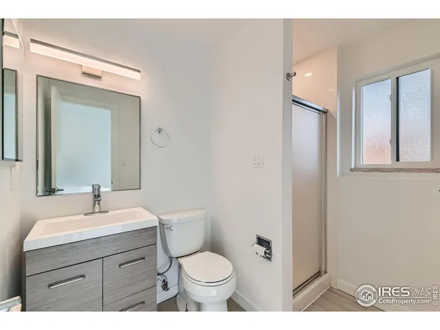 a bathroom with a toilet sink vanity and mirror