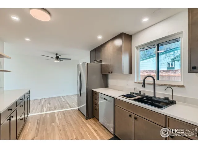 a kitchen with stainless steel appliances a sink cabinets and wooden floor
