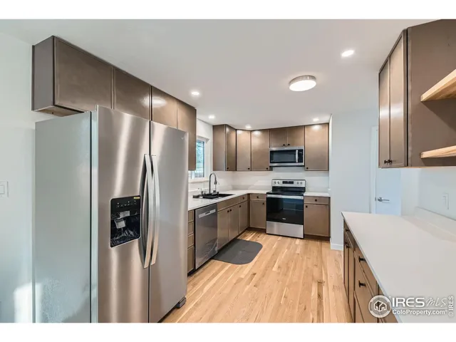 a kitchen with stainless steel appliances a refrigerator sink and stove