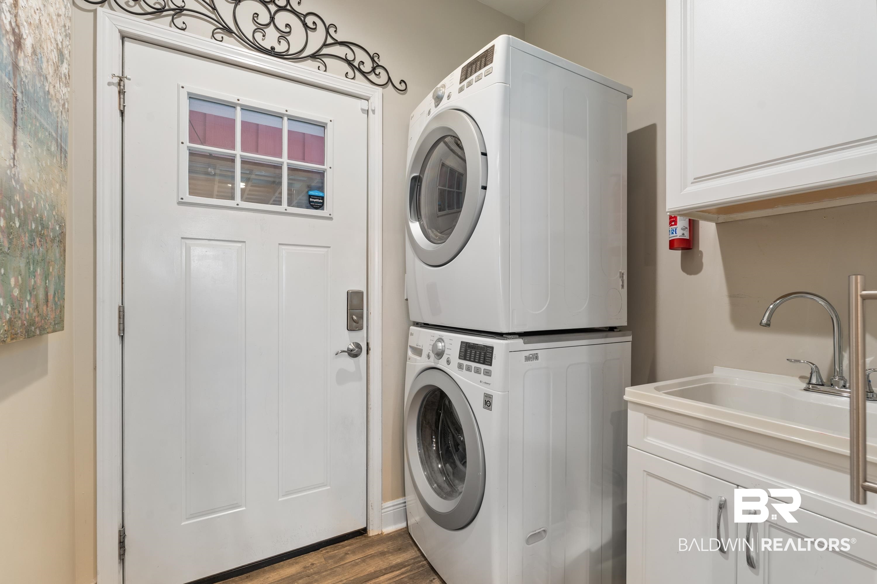 1113 Yellow Daisy Lane Foley, AL 36535 - Photo 20 of 35 Laundry area featuring stacked washer / dryer, cabinet space, and dark wood-style flooring