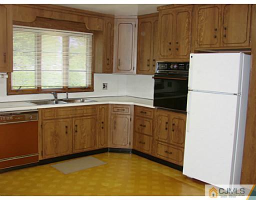422 Ridge Road Dayton, NJ 08810 - Photo 19 of 24 a kitchen with sink a refrigerator and cabinets