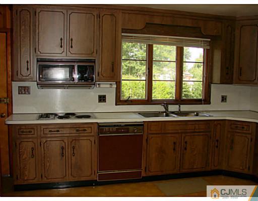 422 Ridge Road Dayton, NJ 08810 - Photo 21 of 24 a kitchen with stainless steel appliances wooden cabinets and a sink