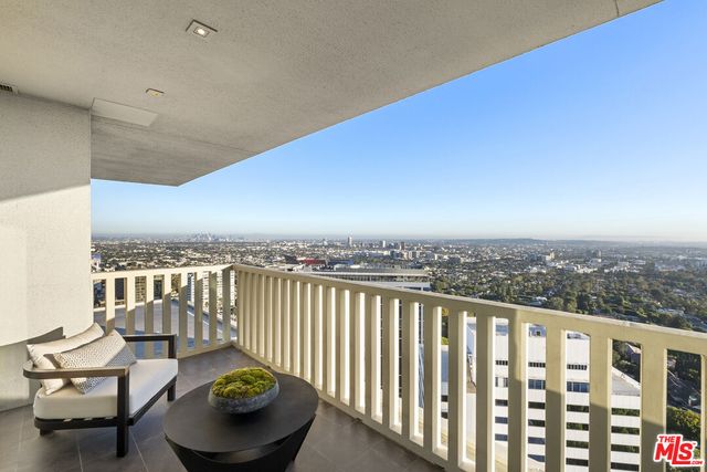 a view of a balcony with chair and potted plants