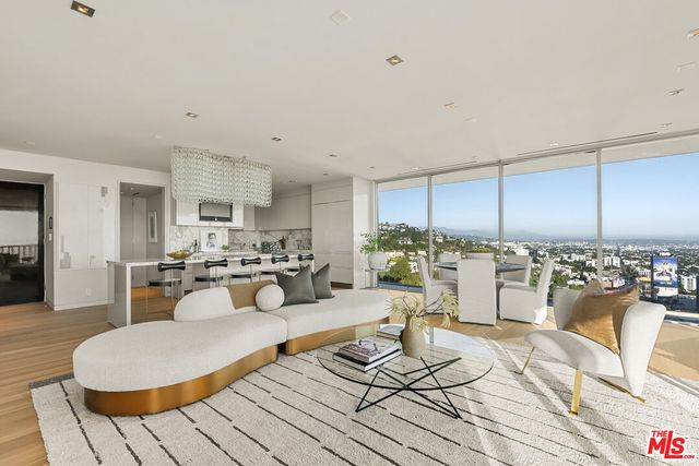 a living room with furniture and a dining table with kitchen view