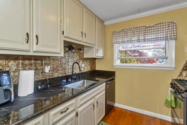 a kitchen with granite countertop a sink a stove and cabinets