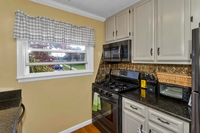 a kitchen with stainless steel appliances white cabinets and a stove top oven