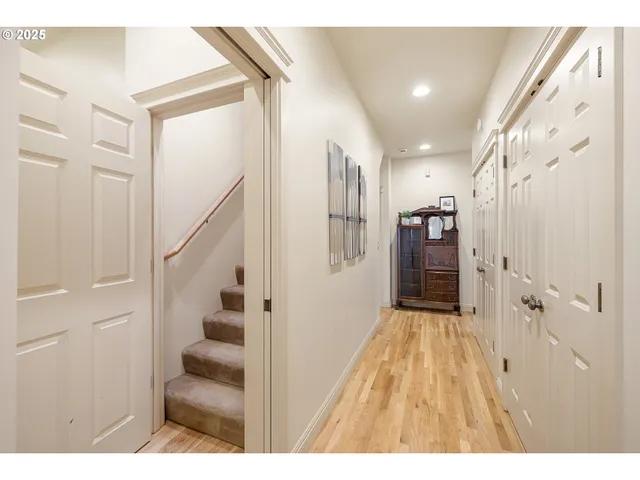 a view of a hallway with wooden floor and entryway