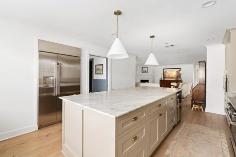 a kitchen with kitchen island sink stove and refrigerator