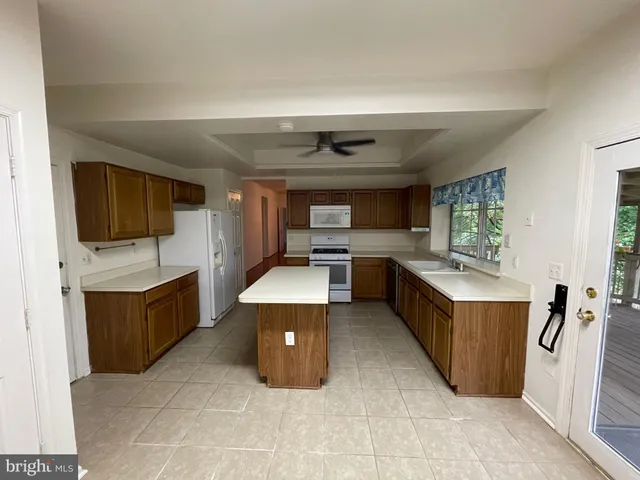 a large kitchen with stainless steel appliances granite countertop a stove top oven a sink dishwasher and a refrigerator