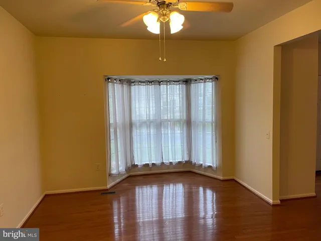 a view of a room with wooden floor and fan
