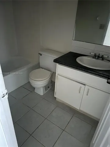 a bathroom with a granite countertop sink a toilet and a mirror