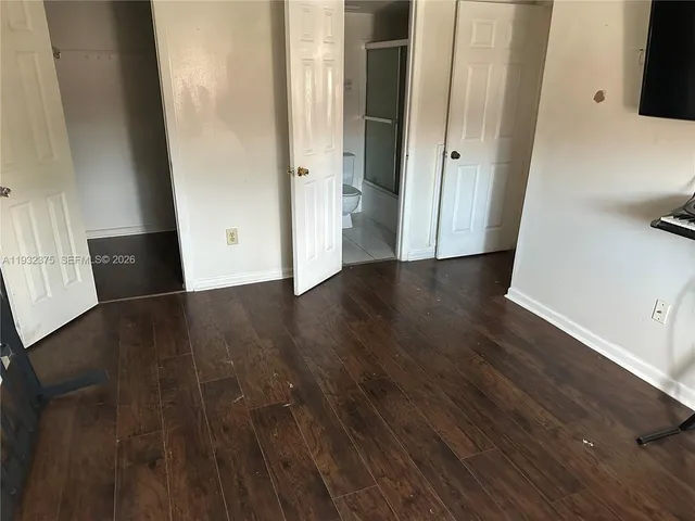 an empty room with wooden floor and entrance