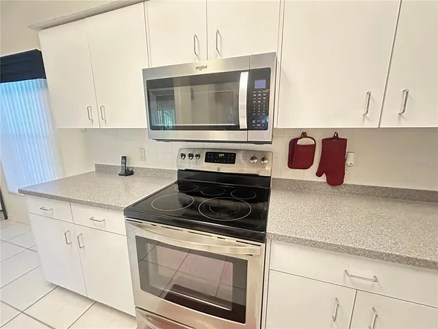 a spacious bedroom with a bed and a chandelier