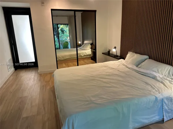 a bedroom with a bed and a large window