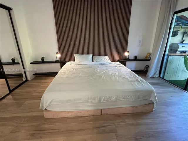 a bedroom with a bed and wooden floor