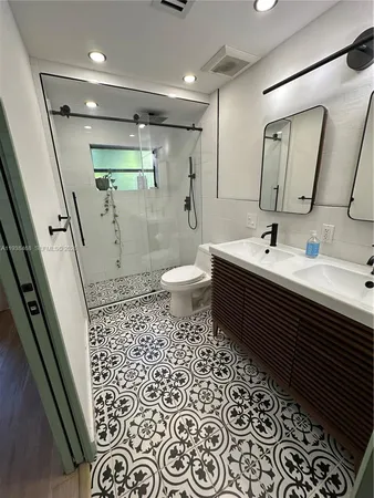 a bathroom with a sink a toilet and a mirror