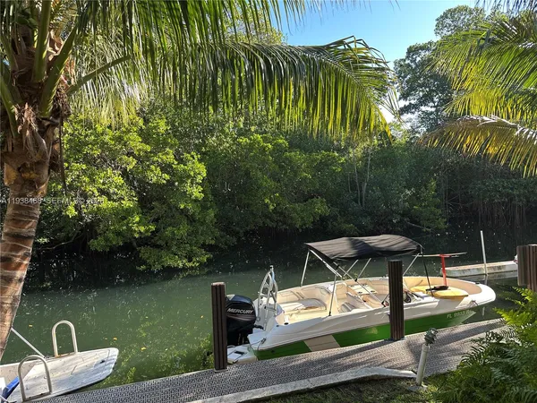 a view of a wooden chairs and table in the patio