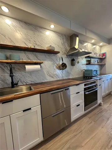 a kitchen with stainless steel appliances granite countertop a sink and wooden cabinets