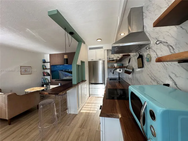 a kitchen with a sink appliances and wooden floor