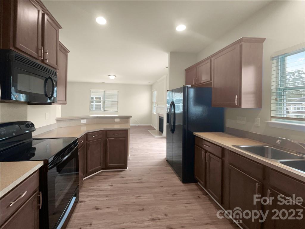 10775 Traders Court Davidson, NC 28036 - Photo 12 of 28 a kitchen with stainless steel appliances granite countertop a stove refrigerator and a sink