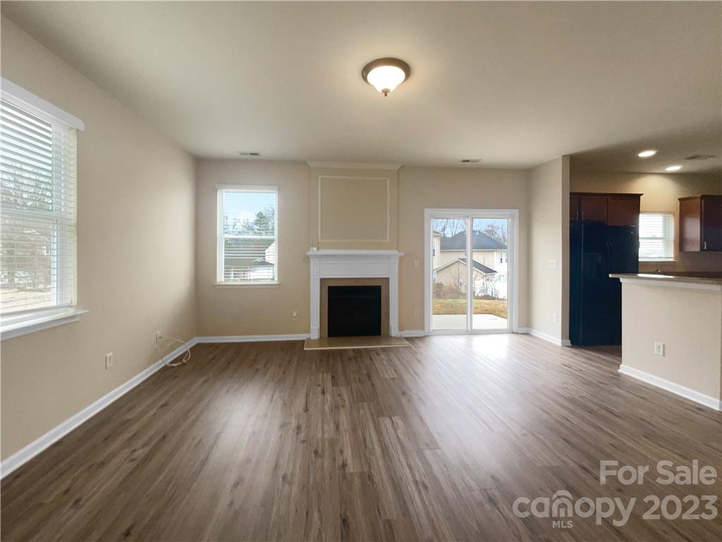 10775 Traders Court Davidson, NC 28036 - Photo 3 of 28 an empty room with wooden floor and a fireplace