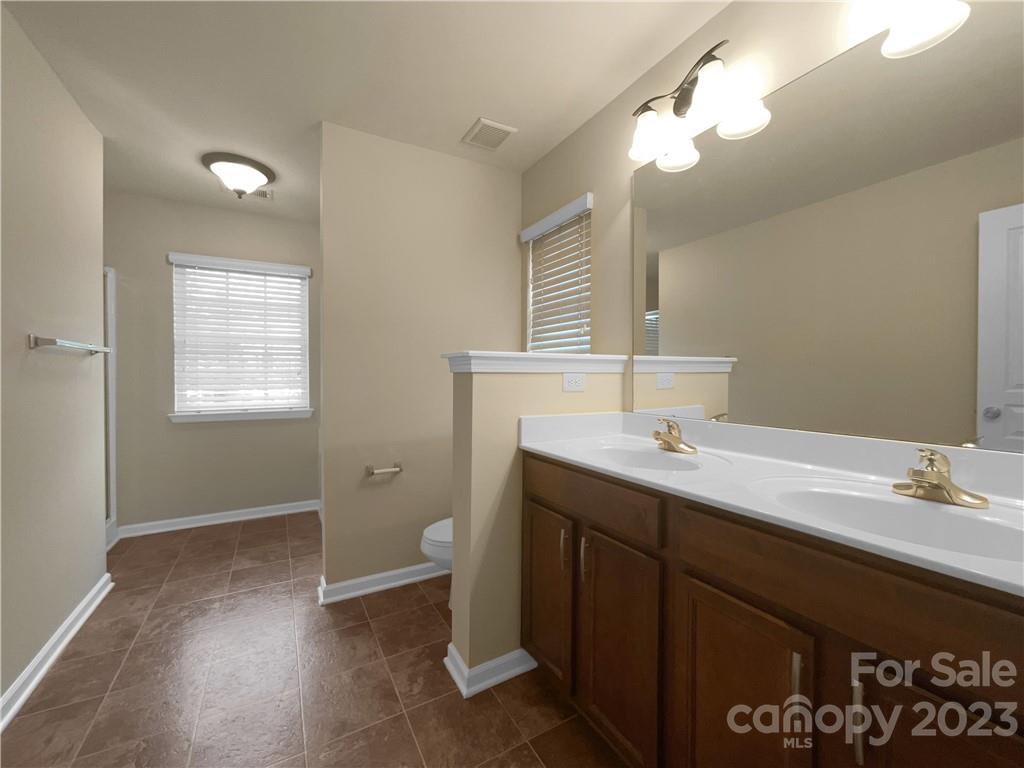 10775 Traders Court Davidson, NC 28036 - Photo 7 of 28 a bathroom with a sink a toilet and a mirror