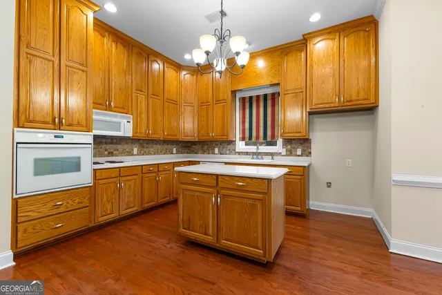 a bathroom with a granite countertop sink a toilet and a mirror