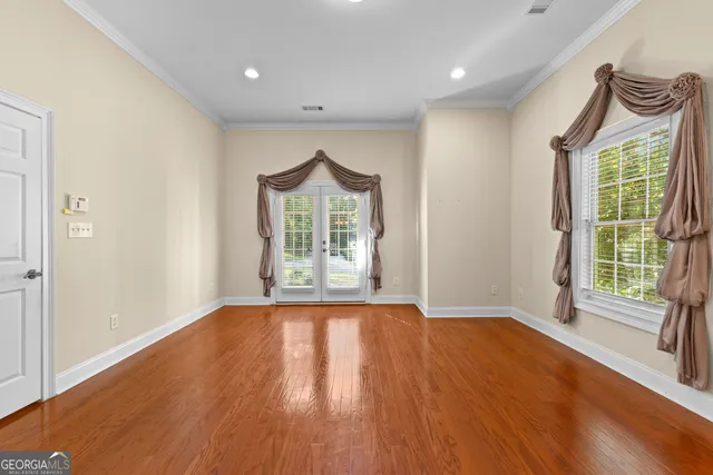 a view of an empty room with wooden floor